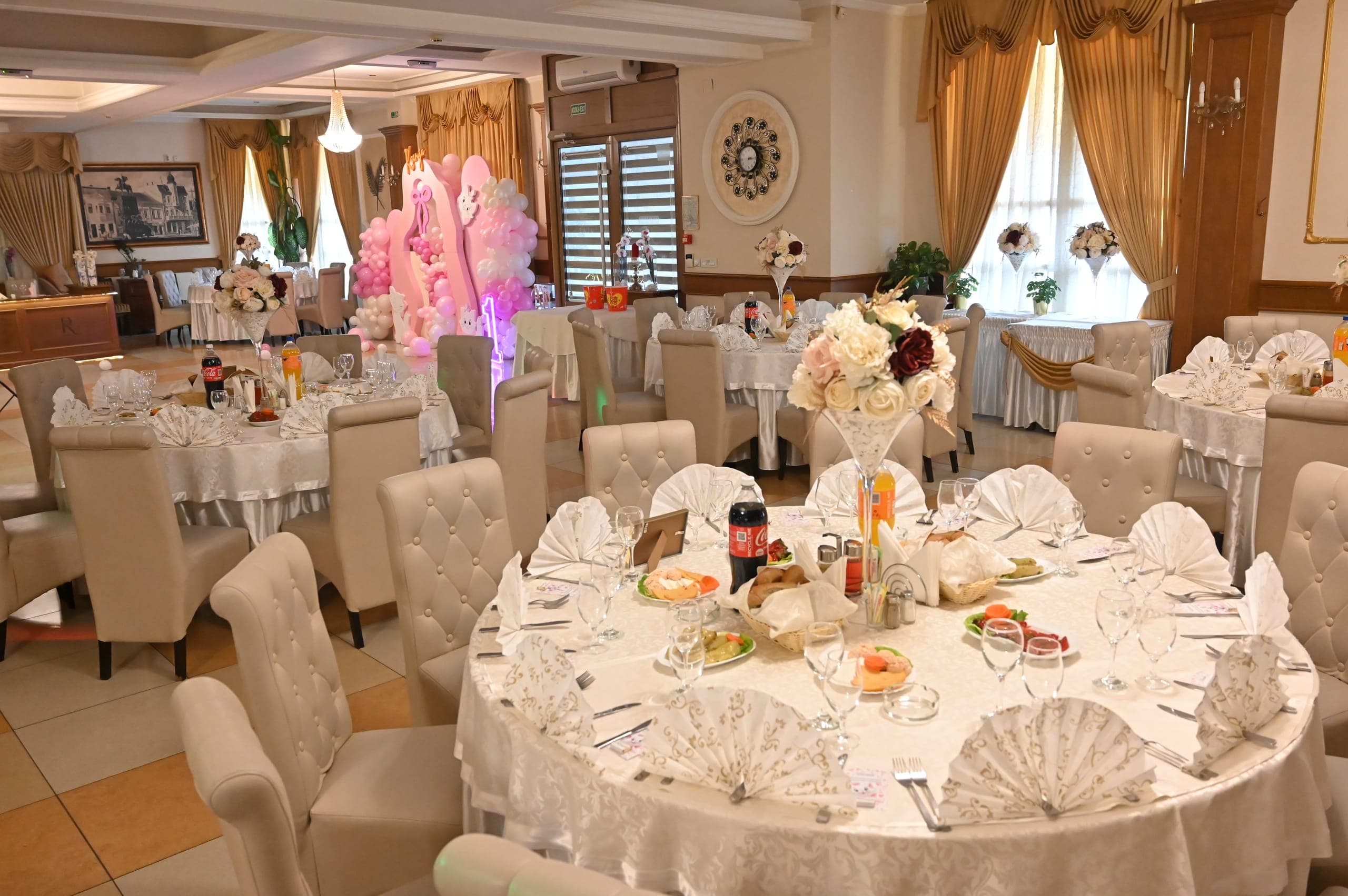 Sala restorana Romansa postavljena za proslavu sa cvetnim dekorom na stolovima
