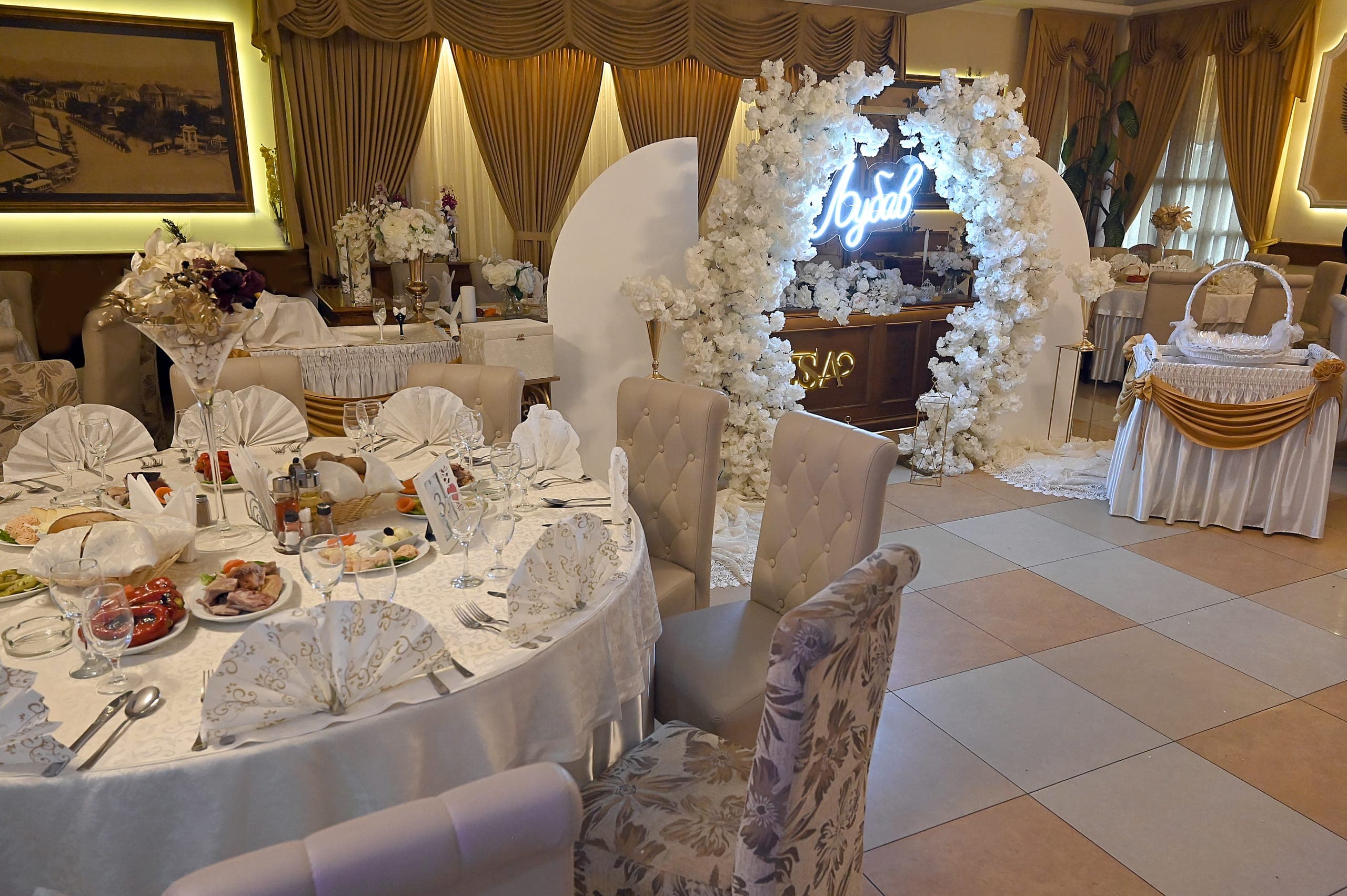 Svečano ukrašena sala restorana Romansa sa cvetnim lukom pripremljena za venčanje
